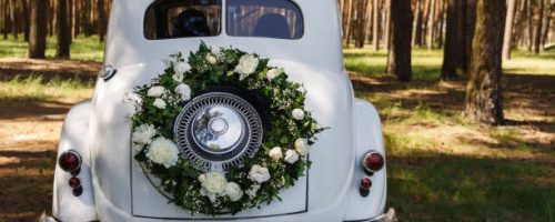 Wedding car with a decoration in the form of a wreath and the word "Wedding"